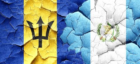 Barbados flag with Guatemala flag on a grunge cracked wallの写真素材