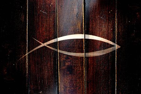 Vintage Christian fish symbol on a grunge wooden panelの写真素材