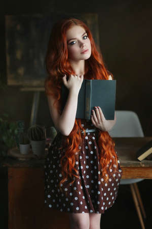 Studio portrait of young beautiful woman with bookの写真素材