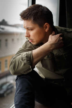 Portrait of man looking through the windowの写真素材