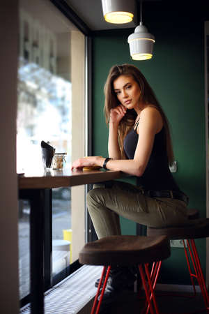 Young woman sitting in cafe with cup of coffeeの写真素材