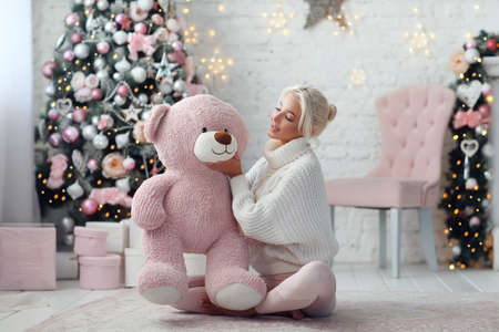 Young beautiful girl with pink bear. Christmas conceptの写真素材