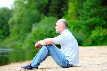 Full length side view of a casual man relaxing at the beachの写真素材