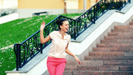 Outdoor fashion closeup portrait of young pretty laughing woman in summer sunny day on streetの写真素材