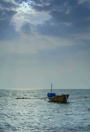 The wooden fishing boat on sea with a sunlightの写真素材