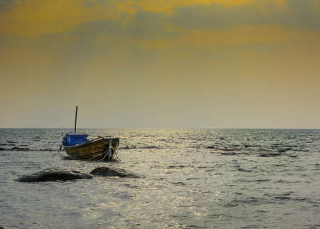 The wooden fishing boat on sea with a sunsetの写真素材