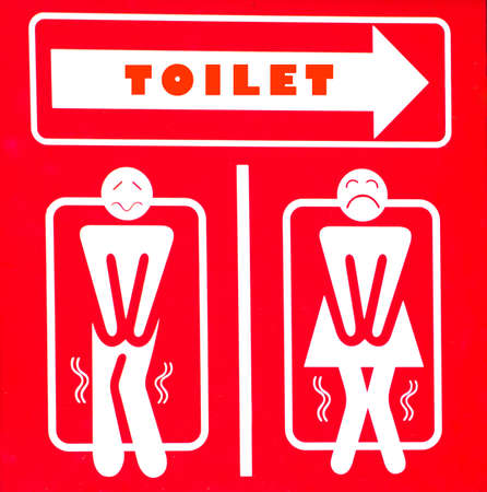 Signpost for men and women or male and female as often used to indicate restrooms with two silhouetted figures standing side by side on redの写真素材
