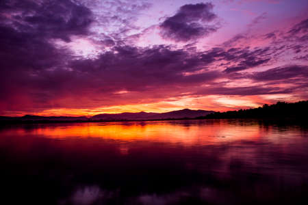 Sunrise over dam with different shades of pink and orangeの写真素材