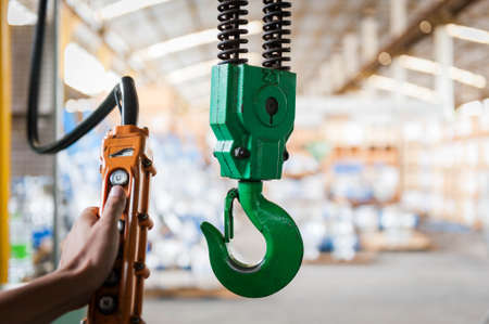 Green crane hook with some industrial valve on the backgroundの写真素材
