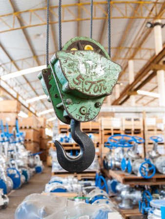 Green crane hook with some industrial valve on the backgroundの写真素材