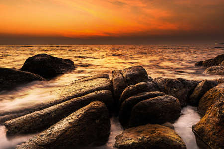 sunset over the sea and rocky coastの写真素材