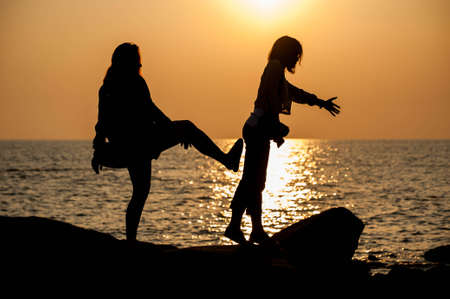 The woman pushing her friend to the seaの写真素材