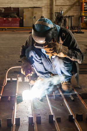 Worker with protective mask welding metal structureの写真素材