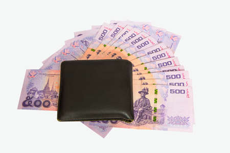 Black leather wallet on pile of moneyの写真素材