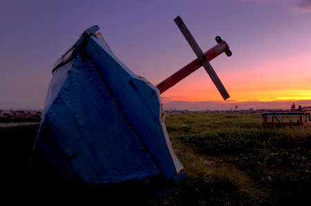 The old fishing boat over a sunset or sunrise skyの写真素材