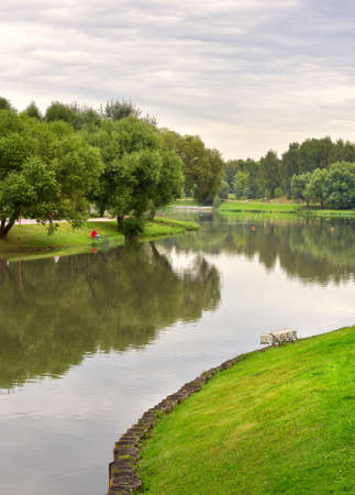 Pond in the summer Park. Picturesque green banks covered with grass and trees. Moscow, Russia, 2020の写真素材