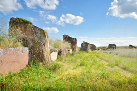 The burial mound of the 5th century BC, steles of red stone under a blue sky. Siberia, Russiaの写真素材