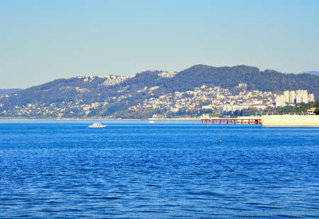 Sochi on the Black Sea coast. Blue water near the shore of a resort town under a blue skyの写真素材