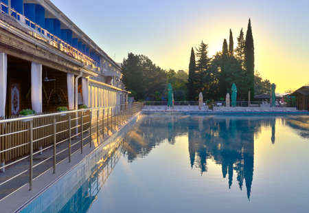 Outdoor swimming pool at dawn. Sanatorium in Sochi on the Black Sea, haze over the water under the blue skyの写真素材