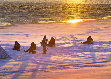 NOVOSIBIRSK, Siberia, Russia-02.07.2021: Winter ice fishing, a group of fishermen on the ice of the Ob River in the bright morning lightのeditorial素材