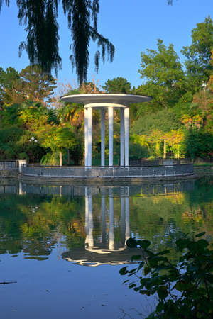 Sochi, Russia, 11.01.2021: Gazebo Rotunda in the Arboretum. Garden pavilion on the lake shore among park greeneryのeditorial素材