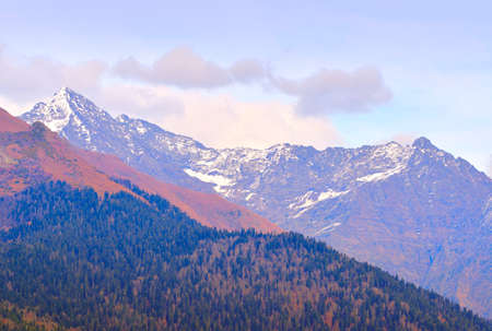 Pink slope of rocky snowy mountains under a cloudy sky. Rosa Khutor, Sochi, Russia, 2021