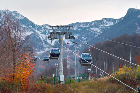 Rosa Khutor, Sochi, Russia, 11.01.2021. Cable car in the mountains. Cabins with the inscription "Rosa Khutor" on cables among the rocks of the Caucasusのeditorial素材