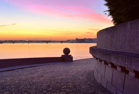 Dawn over the Neva. View of the Trinity bridge and the Palace embankment from the spit of Vasilievsky island. Granite parapet with a stone ball. Saint Petersburg, Russia, 2020の写真素材