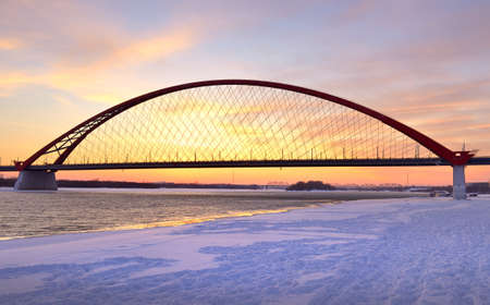 Winter sunrise on the Ob river. Bugrinsky automobile bridge on the frozen snow bank in Novosibirsk. Siberia, Russia, 2021の写真素材