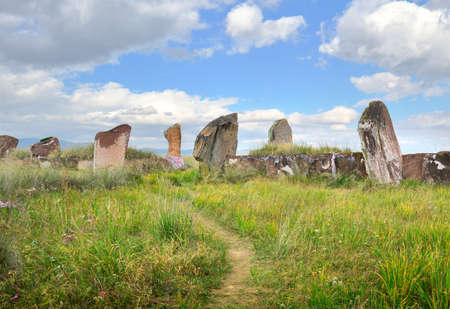 The burial mound of the 5th century BC, steles of red stone under a blue sky. Siberia, Russiaの写真素材