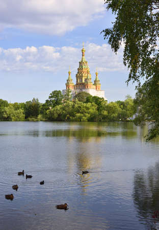 Peterhof, Saint-Petersburg. Russia-09.01.2020: Kolonistsky Park in Peterhof. Cathedral of saints Peter and Paul in the Russian architectural style of the XIX century on the Bank of Olga pond, ducks on the waterの写真素材