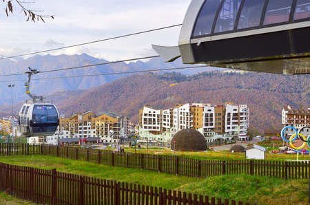 Rosa Khutor, Sochi, Russia, 11.01.2021. Cable car in the mountains. Cabins with the inscription "Rosa Khutor" on cables at the intermediate station of the Olympic Villageのeditorial素材