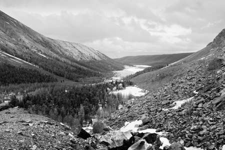Aktru Valley in the Altai Mountains. A tourist base in the distance surrounded by mountains under a...