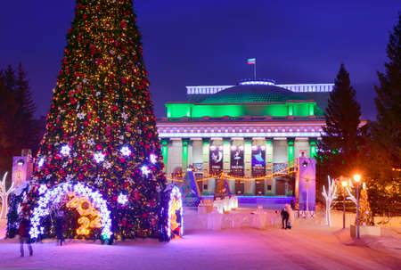 Novosibirsk. Siberia, Russia, 09/01/2022. Lenin Square in the night lights. Christmas tree on the background of the Opera House (posters "Pagliacci", "Bayadere", "Giselle or Villis", etc.)のeditorial素材