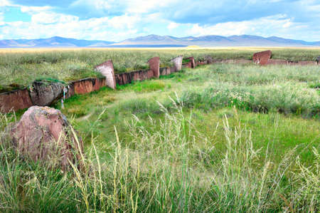 The burial mound of the 5th century BC, steles of red stone under a blue sky. Siberia, Russiaの写真素材