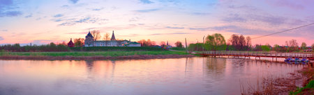 Panorama of the Old Kremlin. The bank of the Kamenka River with a pedestrian bridge at dawn. Suzdal, Russia, 2022の写真素材