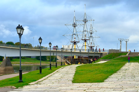 Veliky Novgorod, Russia, 09.28.2022. The trading side of the old town. The embankment of the Volkhov River, a sailboat at the pedestrian bridgeのeditorial素材