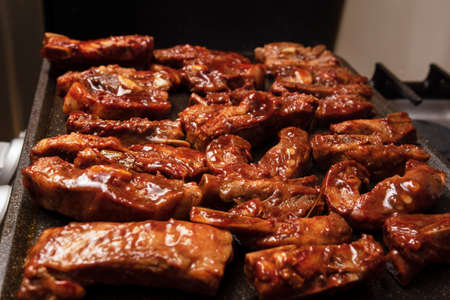 closeup of roasted pork ribs with barbecue sauce and caramelized with honey. Tasty homemade snack or...