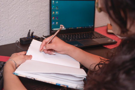 pretty middle-aged latin woman writing in her workspace