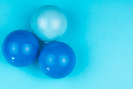 three balls in different shades of plastic on a blue backgroundの写真素材