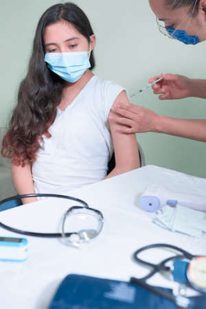 injecting vaccine to adolescent in pandemicの写真素材