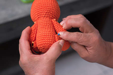 elderly woman 60 year old latin grandmother knitting happy and comfortable inside her homeの写真素材