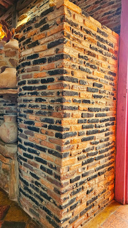 rustic brick wall, with an apparent corner and detail of a shelf, a door on the side and a piece of exposed floorの写真素材