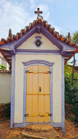 small chapel in colonial style with yellow door, embossed roof and lilac details on the faÃ§adeの写真素材