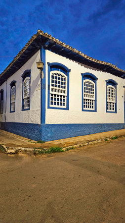 old corner house, blue and white, with old lamp, sidewalk and street detailの写真素材