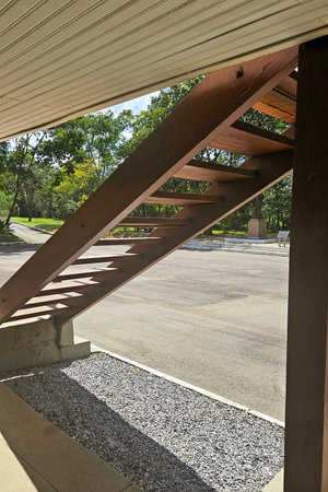 external rustic wooden staircase in building, on gravel floorの写真素材