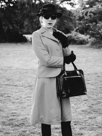 Black and white portrait of an attractive beautiful girl in retro style. She is standing in the park.の写真素材