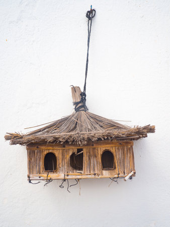 Beautiful wooden bird house on a white stone backgroundの写真素材