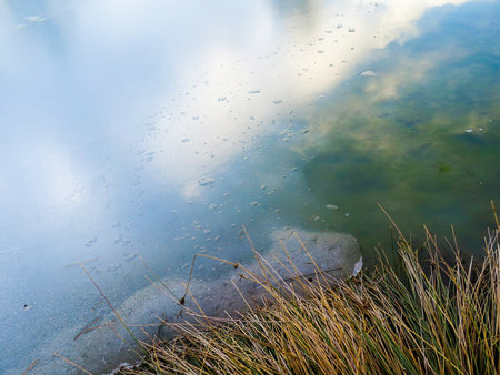 Sky reflection in semi frozen lakeの写真素材