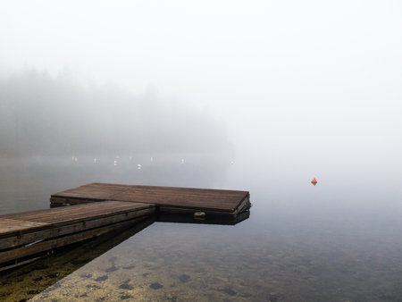 Wooden pontoon on the foggy lakeの写真素材